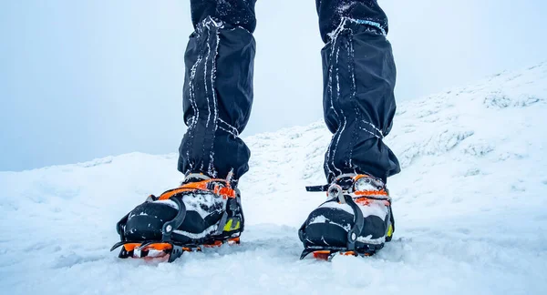 Een man met krampen op sneeuw. — Stockfoto