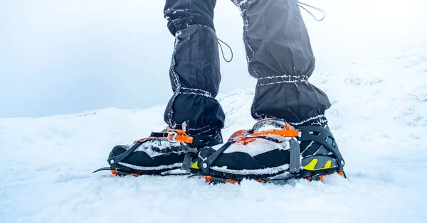 Hombre trekking montaña nevada usando crampones —  Fotos de Stock