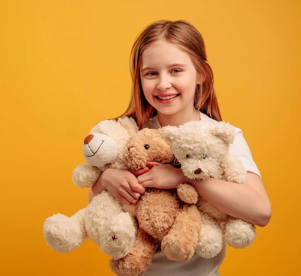 Chica con oso de peluche aislado sobre fondo amarillo — Foto de Stock