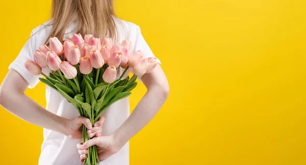 黄色の背景に孤立した花を持つ女の子 — ストック写真