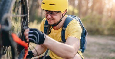 Bisikletçi bisiklet üzerinde zincir tekerleği kontrol ediyor