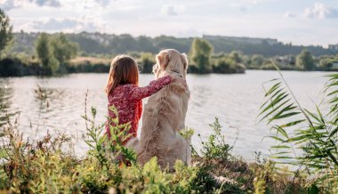 Golden Retriever köpeği olan çocuk dışarıda