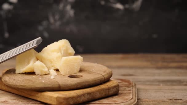 Trozos de queso parmesano junto al rallador — Vídeo de stock