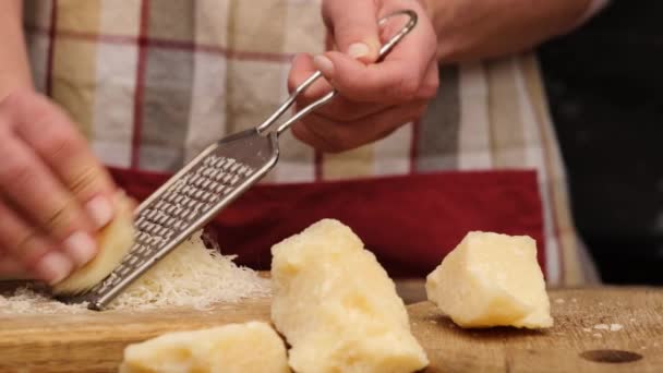 Vrouw die stukjes parmezaanse kaas raspt — Stockvideo