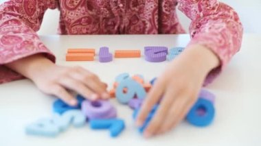 Matematik ödevini rakamlarla çözen küçük kız.