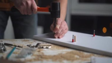 Atölyede bit ve tokmak kullanan adam