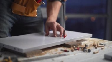 Tornavida kullanan bir adam vidaları beceriyor.