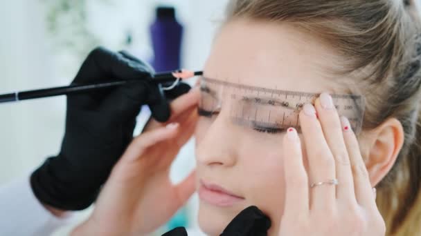 Cosmetólogo haciendo maquillaje permanente de cejas — Vídeo de stock