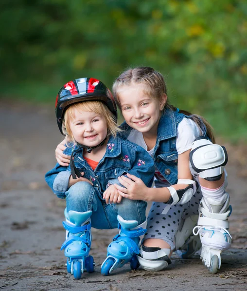 Twee kleine meisjes op rollen — Stockfoto