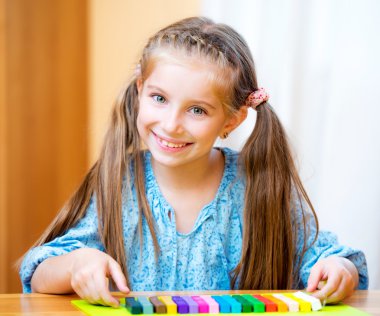 Küçük kız plastikle oynuyor.