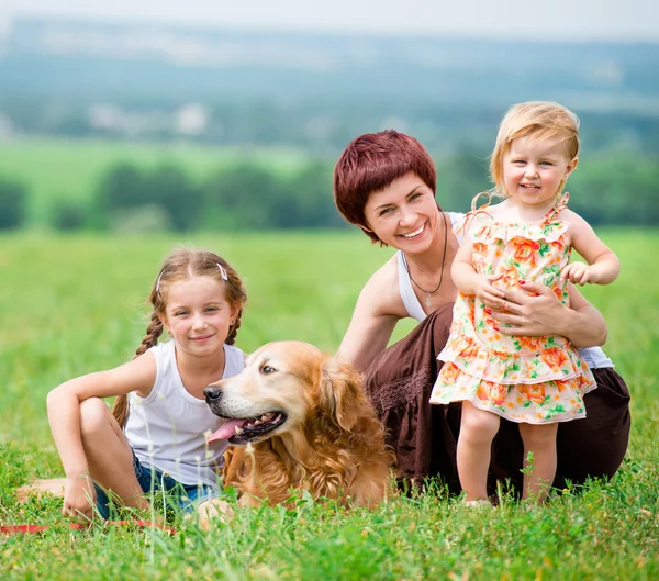 Familj med en golden retriever hund — Stockfoto