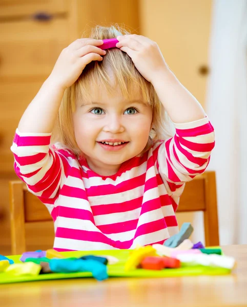 Kleines Mädchen spielt mit Knetmasse — Stockfoto