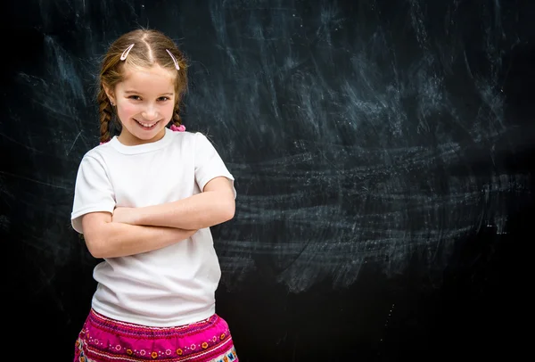 Маленька дівчинка на фоні шкільної дошки — стокове фото