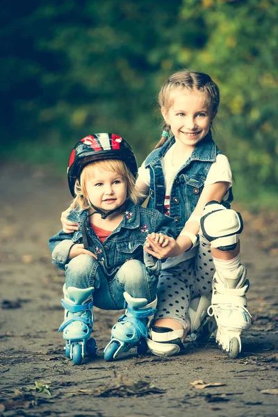 Tekerlekli paten üzerinde iki kız kardeş — Stok fotoğraf