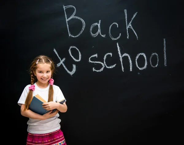 Little girl with a blue book in hands — Stock Photo, Image