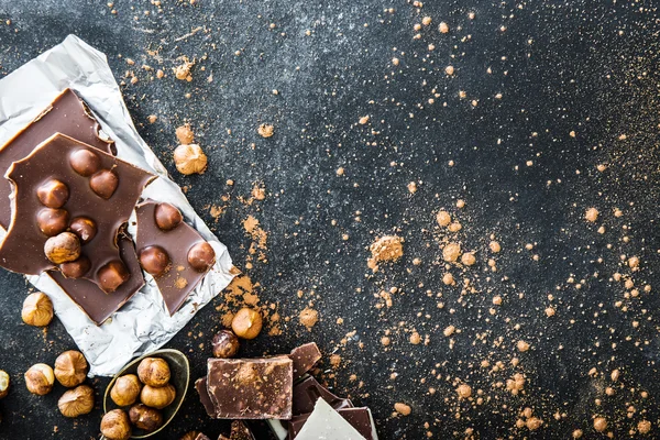 Chocolate and nuts on black table — Stock Photo, Image