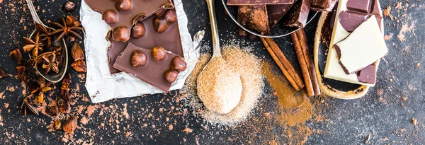 Chocolate y especias en mesa negra — Foto de Stock