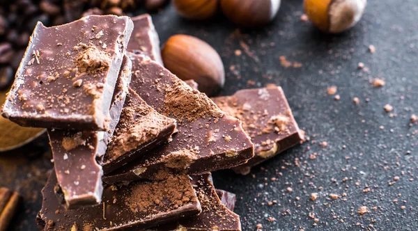 Chocolate and nuts on a black table — Stock Photo, Image