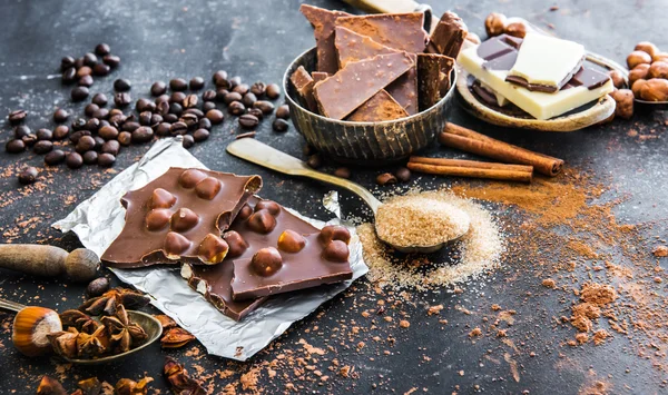 Cioccolato e spezie sul tavolo nero — Foto Stock