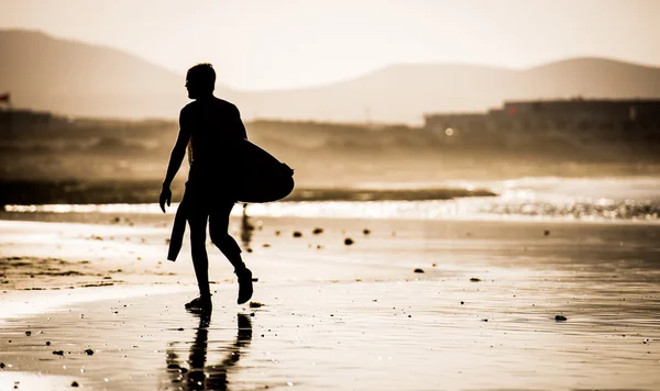 Мужчина с доской для серфинга — стоковое фото