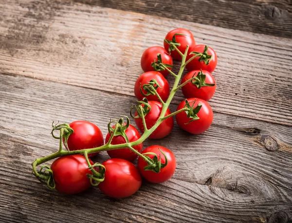 Ramo de tomates em um contexto de madeira — Fotografia de Stock