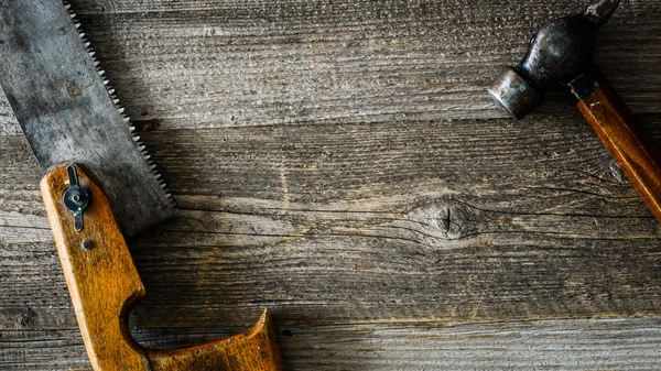 Serra e martelo na mesa de madeira — Fotografia de Stock