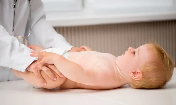 Médico massageando pernas de bebê — Fotografia de Stock