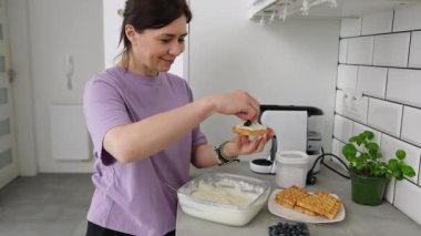 Belçika Waffle 'ı İçin Krema Hazırlayan Kadın Kremalı Waffle Üzerine Taze Yabanmersini Ekliyor