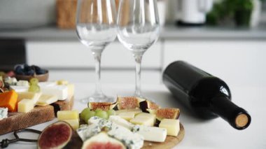 Masada bir şişe şarapla peynir tabağı şarap partisi için iştah açıcı bir tabak olur.