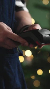 Garson, bulanık bir Noel arkaplanı ve dikey videosuyla Pos Terminali 'nden Bill Miktar Girdi