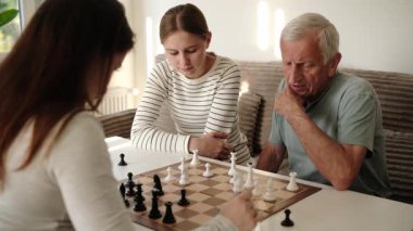 Büyükbabam torunlarıyla satranç oynuyor, hafta sonları birlikte eğleniyor.