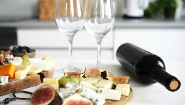 Masada bir şişe şarapla peynir tabağı şarap partisi için iştah açıcı bir tabak olur.