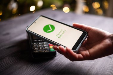 NFC Teknolojisi ile Bir Yılbaşı Masasında Akıllı Telefon Ekranında Ödeme İşlemleri ve Onaylanma Durumu