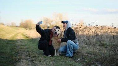 Girls Outdoors Taking A Selfie With A Golden Retriever Dog