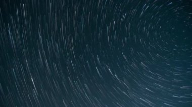 Karanlık bir gecede yıldız izleri zaman içinde kaybolur.