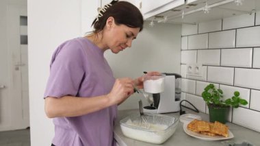 Belçika Waffle 'ları için krema hazırlayan ve mutfağa şeker ekleyen kadın.