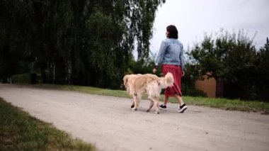 Çekici Kadın Sabah rutininin bir parçası olarak Büyük Altın Köpekle Yürüyor