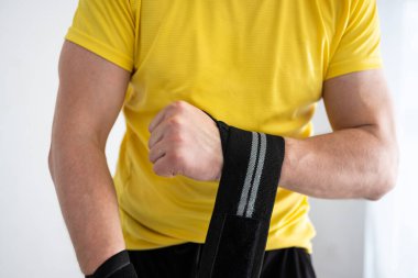 Sporcu, bilekleri eğitime sararak spor yapmaya hazırlanıyor.