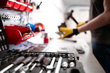 Otomobil tamircisi garajdaki tezgahta Çekiç ile Oto Tamiri