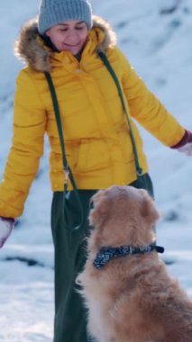 Kadın Altın Avcılarla Öder Köpek Kar Taneleri ve Dikey Video İçin Zıplarken