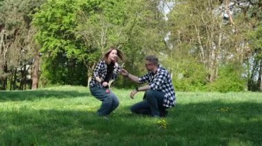 Baba ve kızı yaz parkında Punch Ball oynayıp, saç bandı top oynuyorlar.