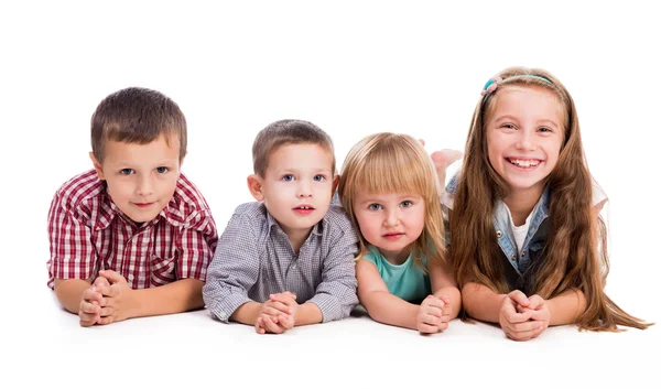 4 つのかわいい子供たちが床の上に横たわる — ストック写真