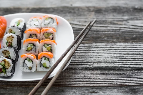 Verschiedene Sushi auf weißem Teller — Stockfoto