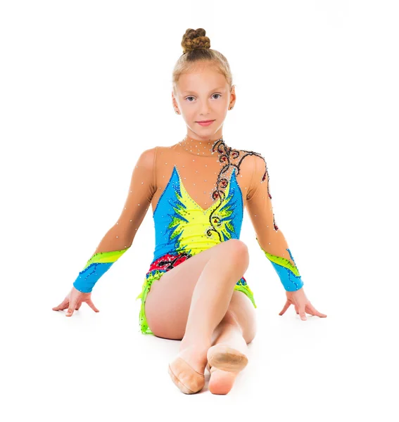 Little gymnast in costume sitting on the floor — Stock Photo, Image