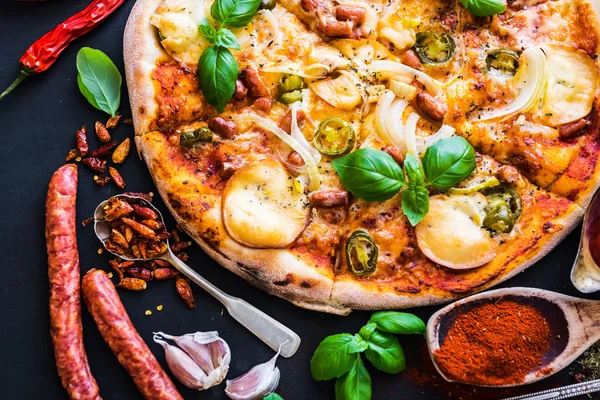 Leckere Pizza auf einer schwarzen — Stockfoto