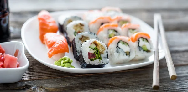 Verschiedene Sushi auf weißem Teller — Stockfoto