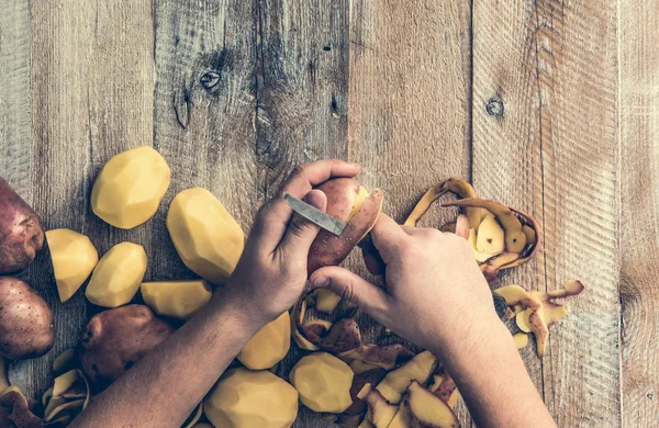 Руки чистят картошку — стоковое фото