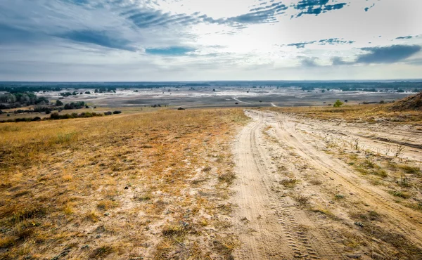 Estrada rolada em um campo — Fotografia de Stock