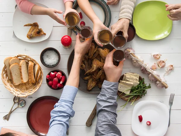 İnsanlar yemek yiyip kadeh tokuşturuyor. — Stok fotoğraf