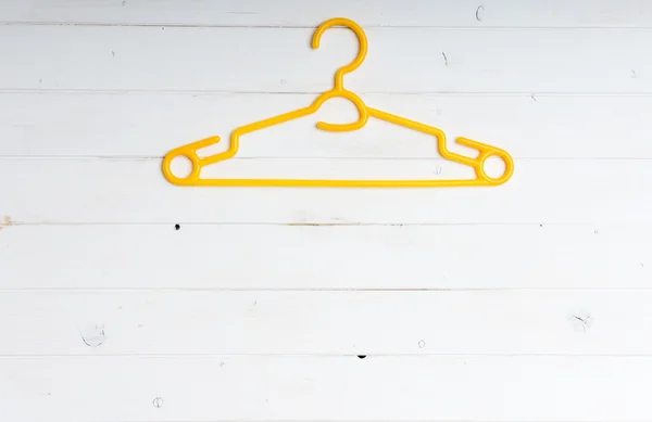 Yellow plastic clothes hanger — Stock Photo, Image